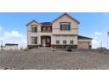 Two-story stucco home with brick accents, manicured gravel landscaping, and attached two car garage at 16197 Paris Way, Brighton, CO 80602