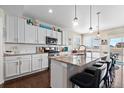 Gourmet kitchen featuring granite countertops, white cabinets, stainless steel appliances, and a large island with bar seating at 16197 Paris Way, Brighton, CO 80602
