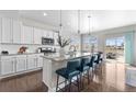 Spacious kitchen showcasing an eat-in island, white cabinetry, granite countertops and stainless steel appliances at 16197 Paris Way, Brighton, CO 80602