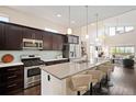 Modern kitchen featuring stainless steel appliances, dark wood cabinets, and a breakfast bar with seating at 5050 Akron St, Denver, CO 80238