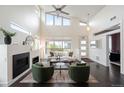 Bright living room with vaulted ceilings, large windows, and a cozy fireplace, creating an inviting space at 5050 Akron St, Denver, CO 80238