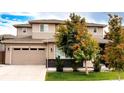 Two-story home with a two car garage, neutral color scheme, and landscaped front yard with healthy trees at 15468 W 50Th Pl, Golden, CO 80403