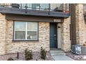 Inviting front entrance with stone accents, stylish door, and manicured landscaping at 11830 W 52Nd Ave, Wheat Ridge, CO 80033