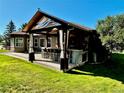 Covered outdoor kitchen with a bar and seating, perfect for entertaining at 7170 Windwood Way, Parker, CO 80134