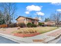 Corner lot featuring a charming brick two-story home, landscaping, and a well-maintained lawn at 9720 W Kentucky Dr, Lakewood, CO 80226