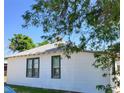 Exterior angle of white home with green trim, featuring a gray roof and classic design at 150 Fulton Ave, Fort Lupton, CO 80621