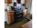 Traditional kitchen featuring a modern black gas range and wooden cabinets at 150 Fulton Ave, Fort Lupton, CO 80621