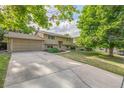 Suburban home with a two-car garage and expansive driveway at 12883 E Nevada Cir, Aurora, CO 80012