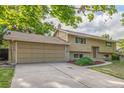 Home with a two-car garage, neutral siding, and a neatly landscaped front yard at 12883 E Nevada Cir, Aurora, CO 80012