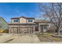 Charming two-story home featuring a stone facade, manicured lawn and blue sky background at 270 Terra Vista St, Brighton, CO 80601