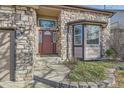 Inviting front entrance showcasing a stone exterior, a decorative door, and well-maintained landscaping at 270 Terra Vista St, Brighton, CO 80601