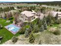 An aerial view showcasing a home, basketball court, and expansive landscape at 10010 Steeplechase Dr, Franktown, CO 80116