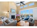 Bright living room with high ceilings, fireplace, and sliding glass doors to outdoor patio at 775 Woodgate Dr, Littleton, CO 80126