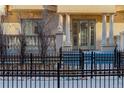 Charming front entrance with black iron fence, stone pathway, and a stately door flanked by decorative columns at 1950 N Logan St # 102, Denver, CO 80203