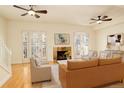 Bright living room with hardwood floors, a stone fireplace, and french doors with plantation shutters at 1950 N Logan St # 102, Denver, CO 80203