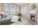 Inviting main bedroom with a fireplace, french doors, and ample natural light at 9581 Firenze Way, Highlands Ranch, CO 80126