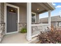 Inviting front porch with white railings, stone accents, and a cozy seating area at 14075 Scarlet Sage St, Parker, CO 80134
