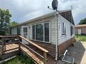Side view of a home in need of repairs, showcasing a wooden ramp and flaking paint at 1105 S Raleigh St, Denver, CO 80219