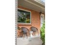 Cozy front porch with brick accents, seating, and an inviting entrance with a small side table at 3322 Simms St, Wheat Ridge, CO 80033