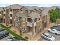 Exterior view showcasing a three-story condo with stone accents and private balconies at 7440 S Blackhawk St # 2-108, Englewood, CO 80112