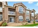 Exterior view showcasing a three-story condo with stone accents and private balconies at 7440 S Blackhawk St # 2-108, Englewood, CO 80112