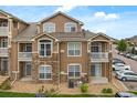 Exterior view showcasing a three-story condo with stone accents and private balconies at 7440 S Blackhawk St # 2-108, Englewood, CO 80112