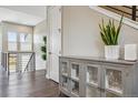 Elegant hallway with hardwood floors and a stylish storage cabinet at 5021 S Prince Pl, Littleton, CO 80123