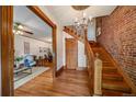 Inviting entryway with hardwood floors, wooden staircase with exposed brick, and chandelier lighting at 1356 N Marion St, Denver, CO 80218