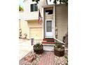 Charming home entrance with a wooden door, American flag, and decorative flower pots at 12935 W 64Th Dr # D, Arvada, CO 80004