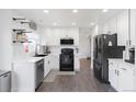 Modern kitchen featuring white cabinets, stainless steel appliances, and hardwood floors at 4715 E 127Th Dr, Thornton, CO 80241