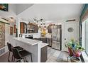 Well-lit kitchen with stainless steel appliances, gray cabinets, breakfast bar, and modern finishes at 8653 E Dry Creek Rd # 1121, Englewood, CO 80112