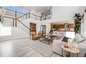 Spacious living room with white walls, open staircase and view of the modern kitchen at 11303 Tango Ln, Parker, CO 80134