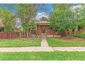 Charming brick home with a cozy front porch and a well-maintained lawn, creating a welcoming curb appeal at 1457 S Franklin St, Denver, CO 80210