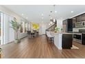 Open-concept living space with hardwood floors, dining area, and modern kitchen at 7602 S Yakima Ct, Aurora, CO 80016