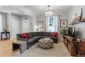 Bright living room featuring a plush gray sectional sofa, stylish ottoman, and decorative accents at 4570 Irving St, Denver, CO 80211