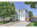 Charming two-story home featuring blue siding, a one car garage and mature trees at 1272 Bluebird St, Brighton, CO 80601