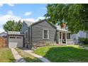 Home exterior featuring a detached garage, grey siding, and a well-maintained lawn at 1738 S Franklin St, Denver, CO 80210