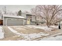 Well-maintained gray home with a large driveway and a charming yellow front door at 2152 Grant St, Longmont, CO 80501