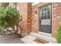 A close-up of the front door to a brick townhouse with well-maintained landscaping at 10310 E Jewell Ave # 55, Aurora, CO 80247