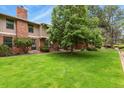 A well-manicured lawn and mature tree highlight this brick townhouse at 10310 E Jewell Ave # 55, Aurora, CO 80247