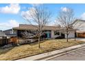 Well-maintained home showcasing a unique dark and light exterior with a vibrant blue front door at 2427 S Eldridge Ct, Lakewood, CO 80228