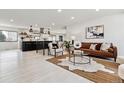 Bright living room with an open concept view of the kitchen, white floors, and modern décor at 2427 S Eldridge Ct, Lakewood, CO 80228