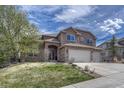 Charming two-story home featuring a stone facade, three-car garage, and a well-manicured front lawn at 580 Eagle Nest Ct, Golden, CO 80401