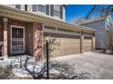 Well-kept home featuring a three-car garage, brick accents, and a cozy, covered porch entrance at 18655 E Garden Pl, Aurora, CO 80015