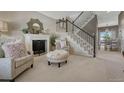 Inviting living room featuring a fireplace, plush seating, and a staircase leading to the upper level at 18655 E Garden Pl, Aurora, CO 80015