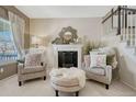Cozy living area featuring a decorative fireplace, ample natural light, and two comfortable armchairs creating an inviting space at 18655 E Garden Pl, Aurora, CO 80015