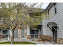 Two-story condo building with stone and siding exterior, balcony, and well-kept landscaping at 3281 E 103Rd Pl # 1403, Thornton, CO 80229