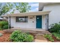 Inviting front porch features black iron supports, a vibrant door, and meticulously curated landscaping at 5315 Newland St, Arvada, CO 80002