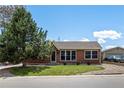 Charming brick home featuring a well-kept lawn, complemented by a lush tree and a detached garage at 160 Northglenn Dr, Northglenn, CO 80233