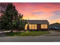 A well-maintained, single-story brick home with a well-manicured lawn at sunset at 160 Northglenn Dr, Northglenn, CO 80233